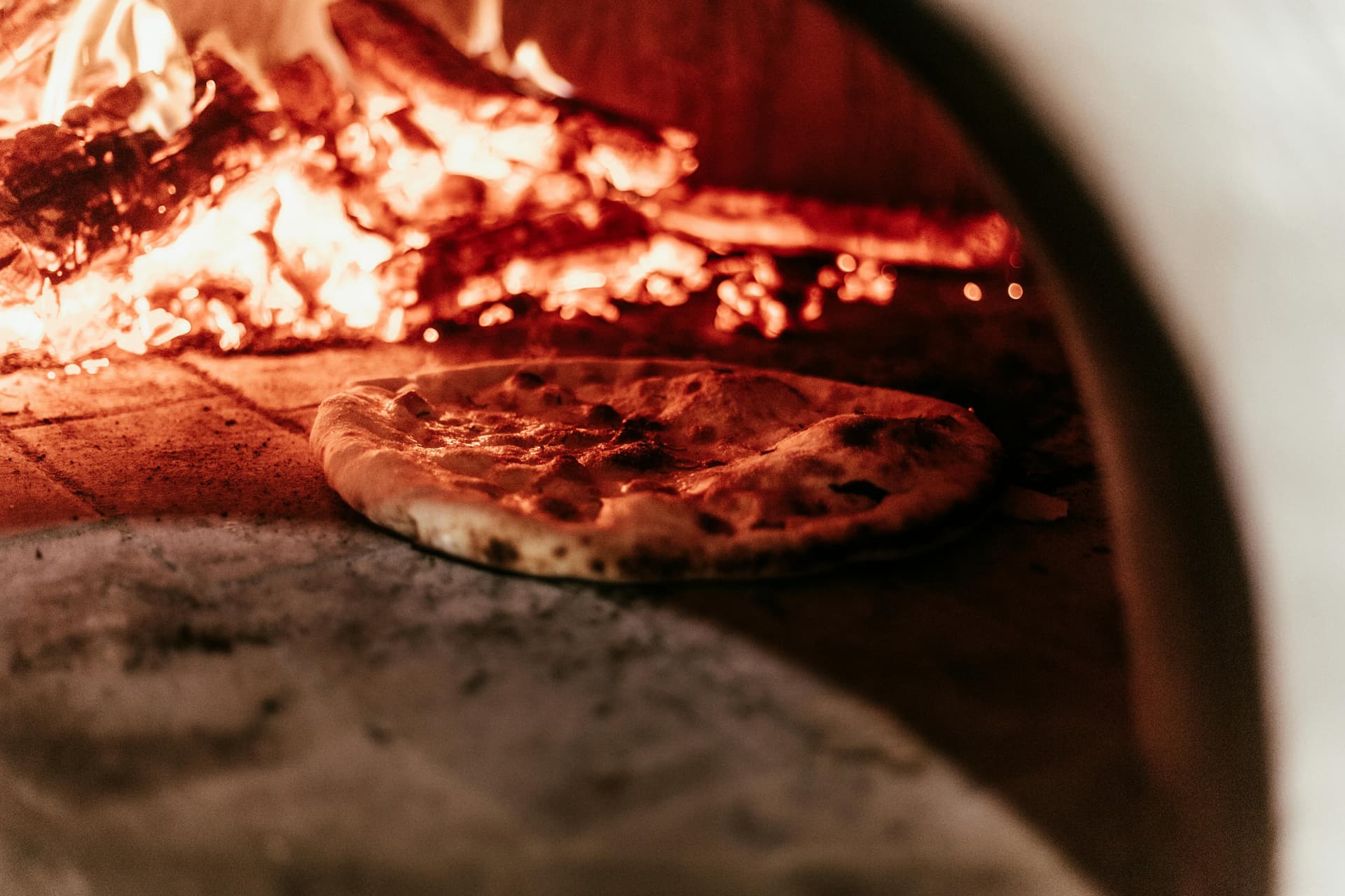 Pizza baking in traditional wood-fired oven